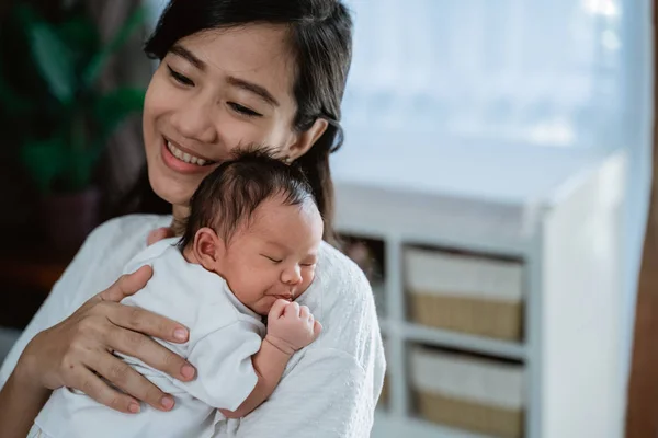 Aziatische moeder omarmen dragen pasgeboren kleine dochter — Stockfoto