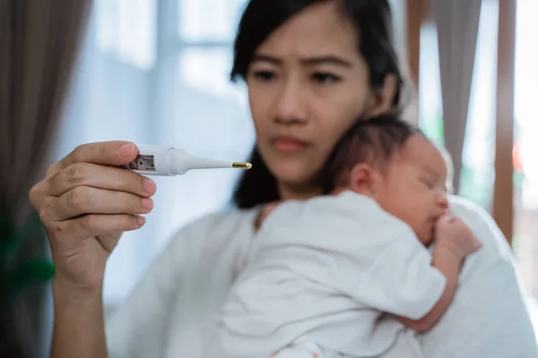 asian mother using thermometer feel worried about their childrens health