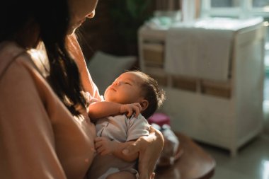 küçük bebek uyurken annesi taşır