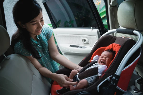 母親が車の座席に座ると泣いている小さな娘 — ストック写真