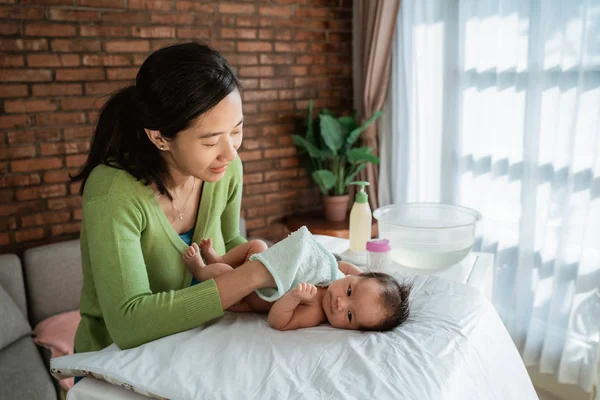 Moeder whipes haar klein meisje met Wash lap — Stockfoto