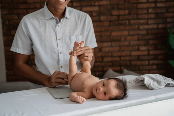 Asian father rubbing baby buttocks — Stock Photo, Image