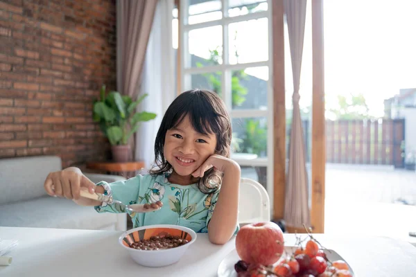 Bambino gustare la colazione con una ciotola di cereali a casa — Foto Stock