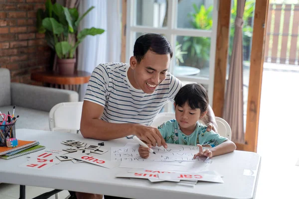 Niño pequeño estudiando con su padre en casa — Foto de Stock