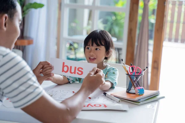 Papá enseñando a su hija a leer con tarjeta — Foto de Stock