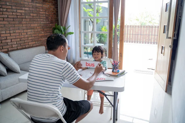 Papá enseñando a su hija a leer con tarjeta — Foto de Stock