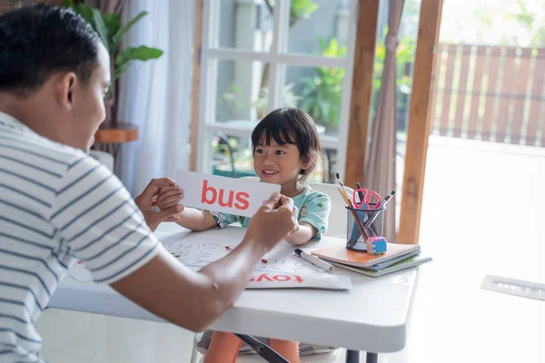 Feliz niño aprendiendo y estudiando junto con los padres en casa — Foto de Stock