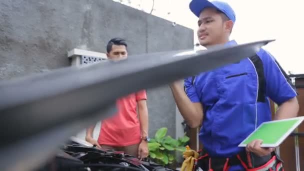 Technician helpen klant vaststelling van zijn auto — Stockvideo