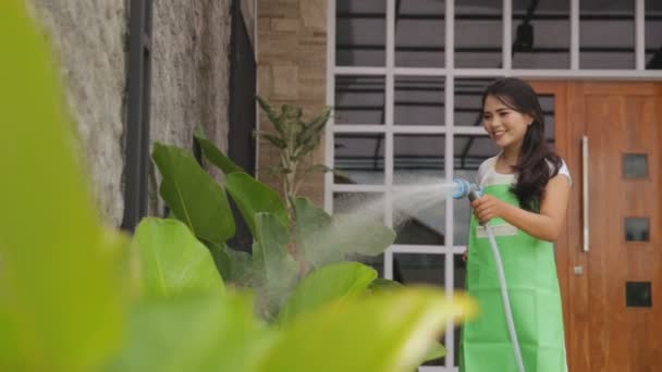 Kvinna vattna sin trädgård — Stockvideo