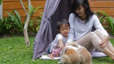 Anne ve kızı tavşanı besliyor.