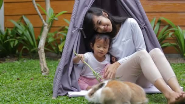 Moeder en dochter voeden konijn — Stockvideo