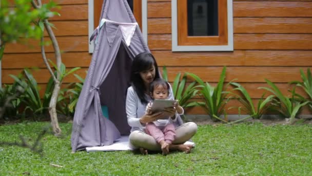 Met behulp van tablet tijdens het spelen thuis achtertuin — Stockvideo