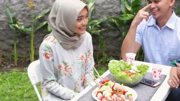 Азиатские люди, питающиеся в саду — стоковое видео