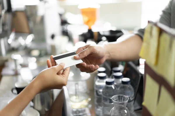 Close up hand of the buyer gives a credit card to the seller — Stock Photo, Image