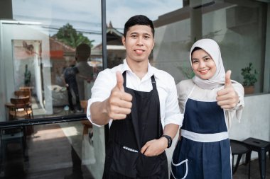 Baş parmakları havada iki garson.