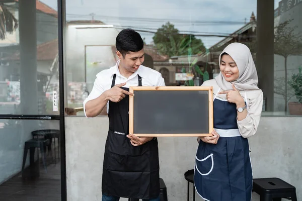 Twee serveerster staan houden een schoolbord — Stockfoto