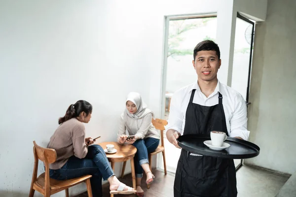 Garçom masculino serve uma xícara de café — Fotografia de Stock