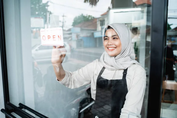 Asiatischer verschleierter Kellner hält ein offenes Schild — Stockfoto