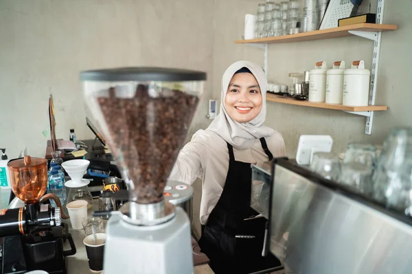 Garçonete feminina segurando um moedor de café — Fotografia de Stock