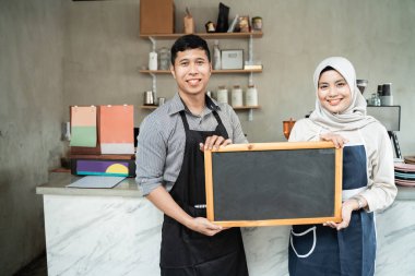 Karatahta tutan bir çift garson.