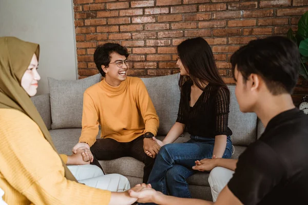 Asiatiska unga par möter varandra när de håller varandra i hand med vänner — Stockfoto