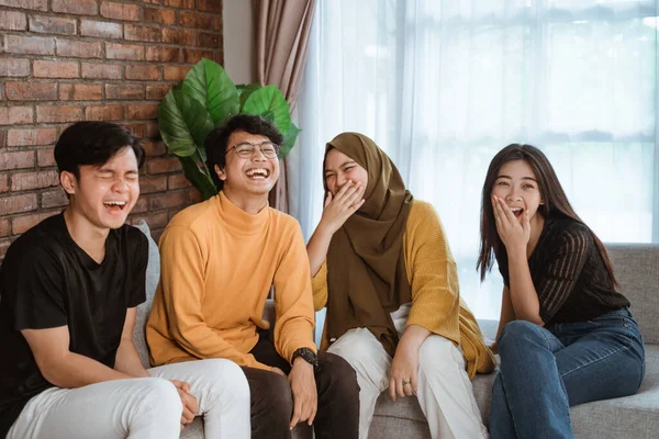 Groep studenten zitten samen op de bank samen lachen — Stockfoto