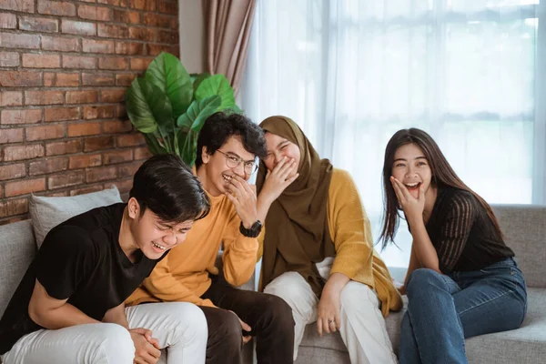 Sekelompok anak muda Asia duduk bersama di sofa tertawa bersama — Stok Foto