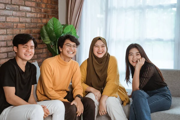 Sekelompok siswa duduk bersama di sofa tertawa bersama — Stok Foto