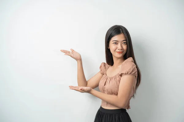 Aantrekkelijk meisje met lang haar staan terwijl de hand gebaren presenteren iets — Stockfoto