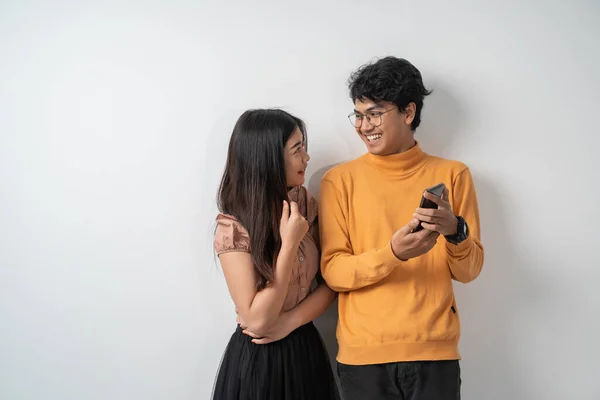 Jovem casal conversando enquanto está segurando um telefone inteligente — Fotografia de Stock