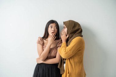 Peçeli Asyalı kız şok olmuş bir ifadeyle genç kızın kulağına fısıldadı.