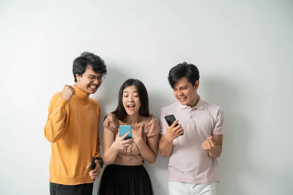 Fiatal barátok csoportja nagyon izgatott kifejezések használata közben az okos telefonok — Stock Fotó