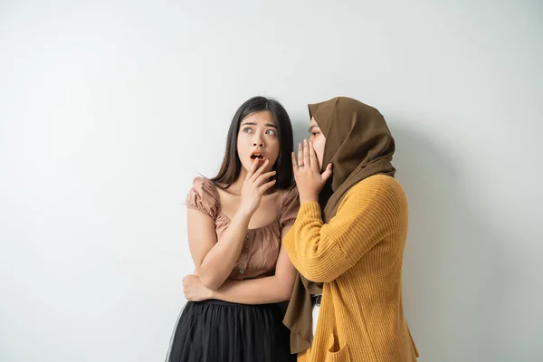 Menina velada sussurrou para a jovem com uma expressão chocada — Fotografia de Stock