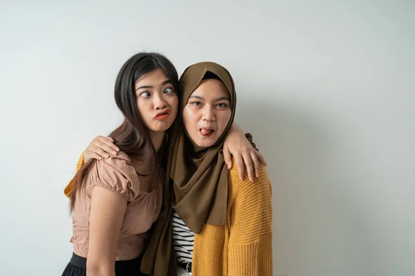 Två vänliga flickor posera dumma ansikten när man tittar på kameran — Stockfoto
