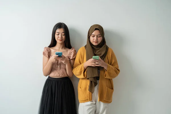 Dvě přátelské dívky jsou velmi vážné při používání svých chytrých telefonů — Stock fotografie