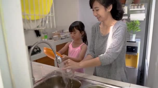 Criança gosta de lavar os pratos juntos — Vídeo de Stock