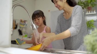 Çocuk bulaşıkları beraber yıkamaktan hoşlanıyor.