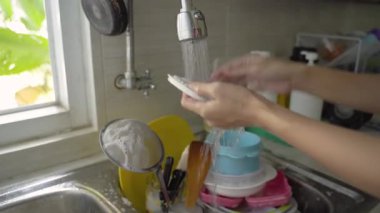 Kadın bulaşık yıkıyor.