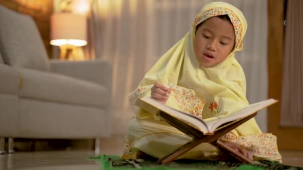 Дівчина читає Куран сама вдома — стокове відео