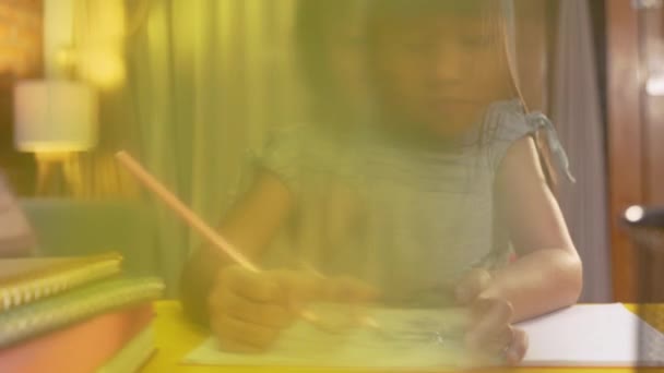 Kid studying by herself in the evening — Stock Video