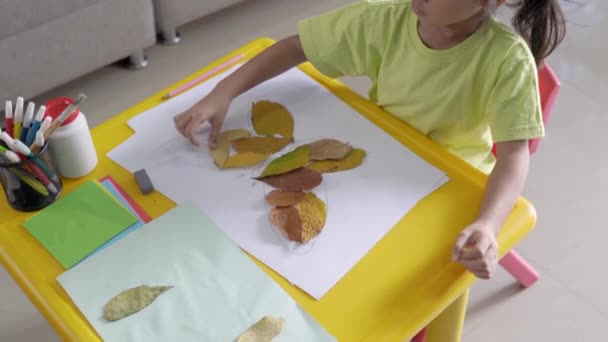 Atividade infantil fazendo artesanato a partir de folhas secas — Vídeo de Stock