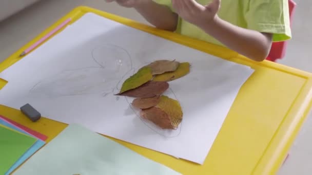 Atividade infantil fazendo artesanato a partir de folhas secas — Vídeo de Stock