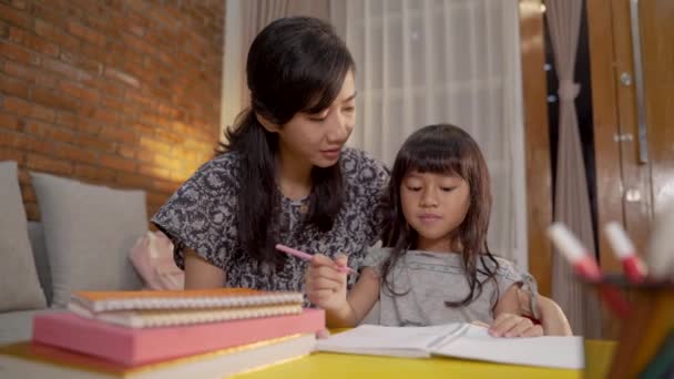 Мать и дочь вместе учатся на дому — стоковое видео