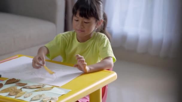 Atividade infantil fazendo artesanato a partir de folhas secas — Vídeo de Stock