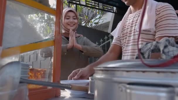Sokak yemekleri satıcısı bir kase bakso uzatıyor. — Stok video