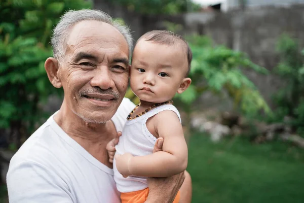 Närbild av farfar bar ett litet barnbarn — Stockfoto