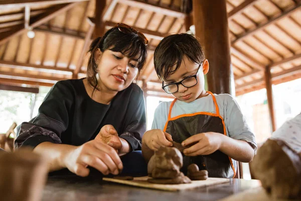 Madre y su hijo tratan de hacer artesanías de barro — Foto de Stock