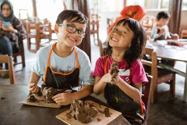 Abi ve kız kardeş el işi yapmaya çalışıyor.