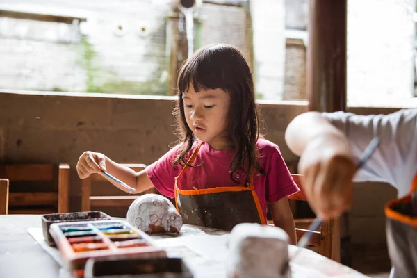 Niña haciendo artesanía y pintando cerámica —  Fotos de Stock