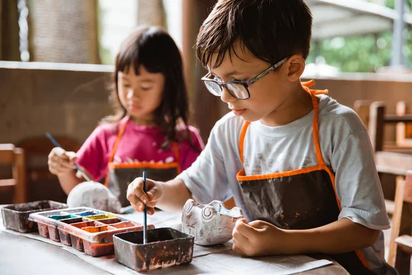 Muchacho pintando artesanías con colores — Foto de Stock